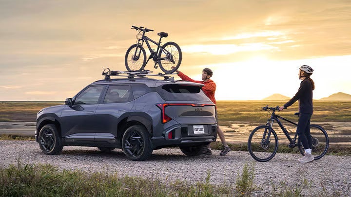 2027 Kia Seltos with roof-mounted bicycles at sunset